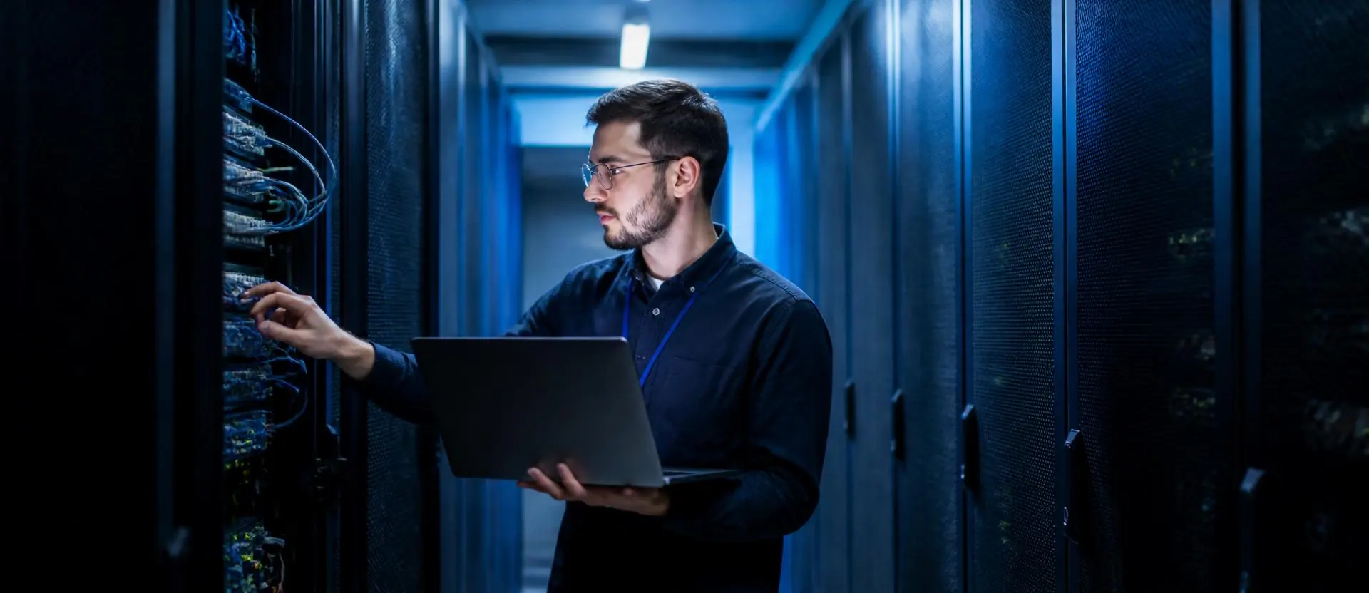 Technicien informatique en intervention dans une salle serveur