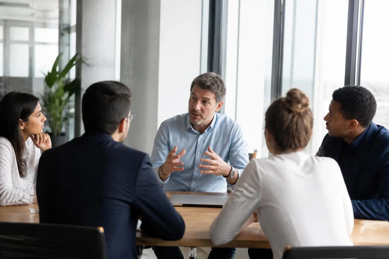 Manager en réunion d'équipe autour d'une table de travail
