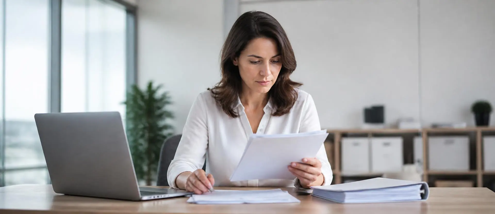 Gestionnaire de paie concentrée sur un dossier dans un bureau lumineux